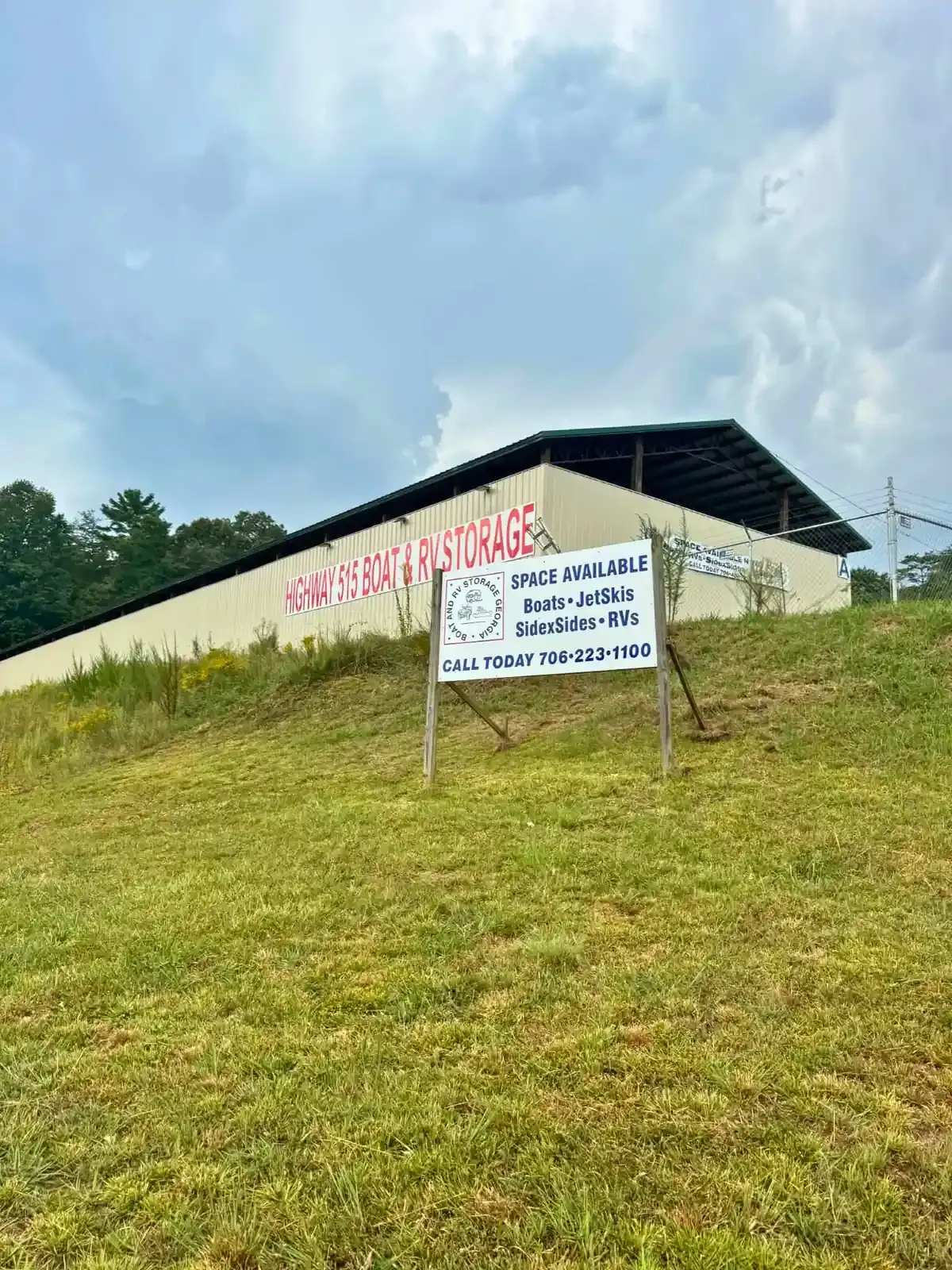 White sign on a hill outside a metal building